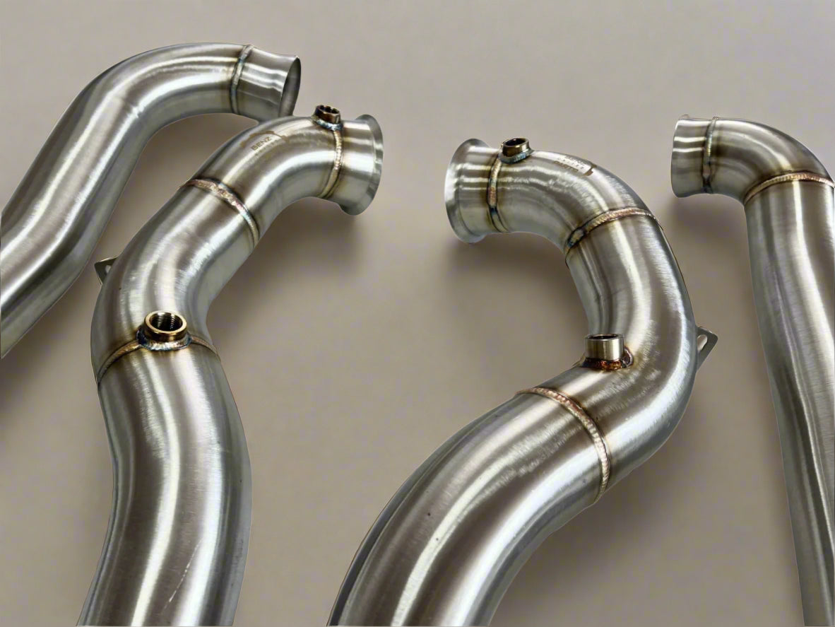 Close-up view of premium handcrafted AMG E63/E63s downpipes featuring TIG welding and 304 stainless steel construction.