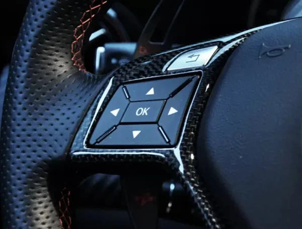 Close-up of AutoTecknic carbon fiber steering wheel trim on Mercedes-Benz C-Class steering wheel