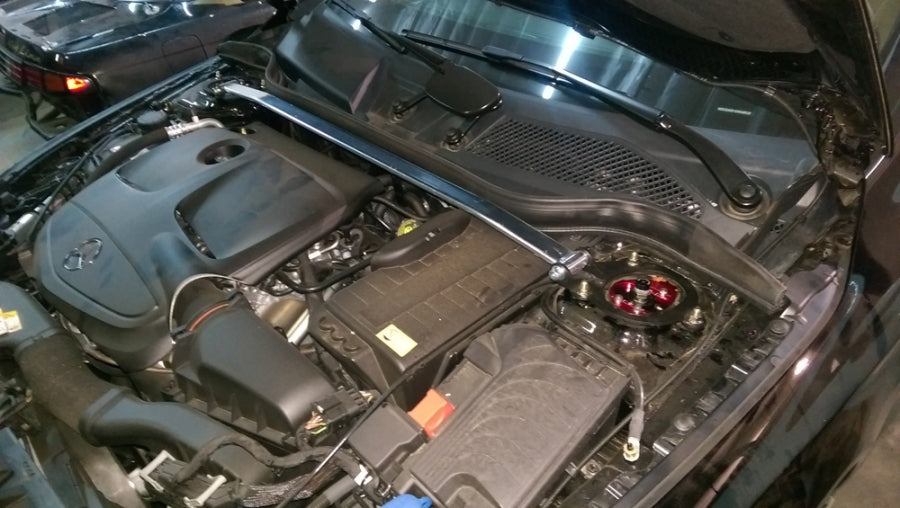 Megan Racing front strut tower bar installed on Mercedes CLA45 AMG engine bay showing chassis reinforcement