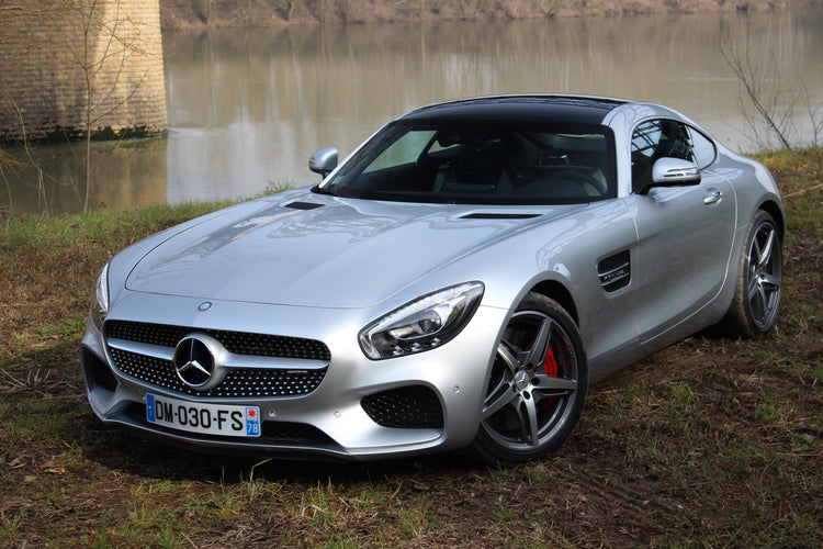 Mercedes-AMG GT parked by river showcasing luxury design and performance stance