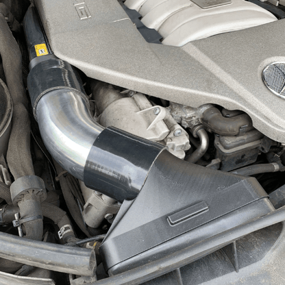 Detailed view of carbon fiber and nylon composite adapter pieces with 2-inch silicone couplers for M156 AMG intake system