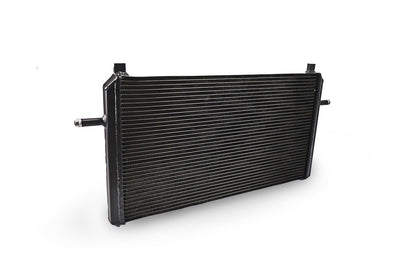 A black front mount heat exchanger for Mercedes CLA45 AMG cooling upgrade, with a ribbed surface and metal construction.