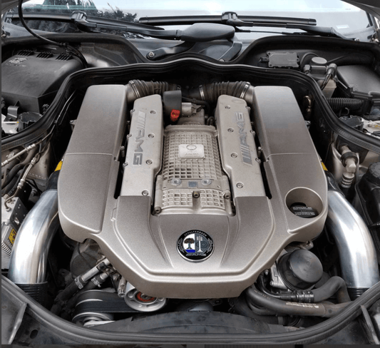 Aluminum intake pipes installed on Mercedes AMG M113K engine showing upgraded airflow and OEM-fit engine bay appearance
