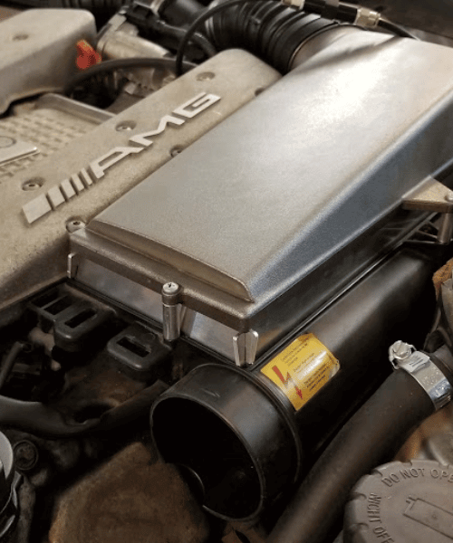 Mercedes AMG M113K intake filter spacer mounted on supercharged E55 AMG intake assembly