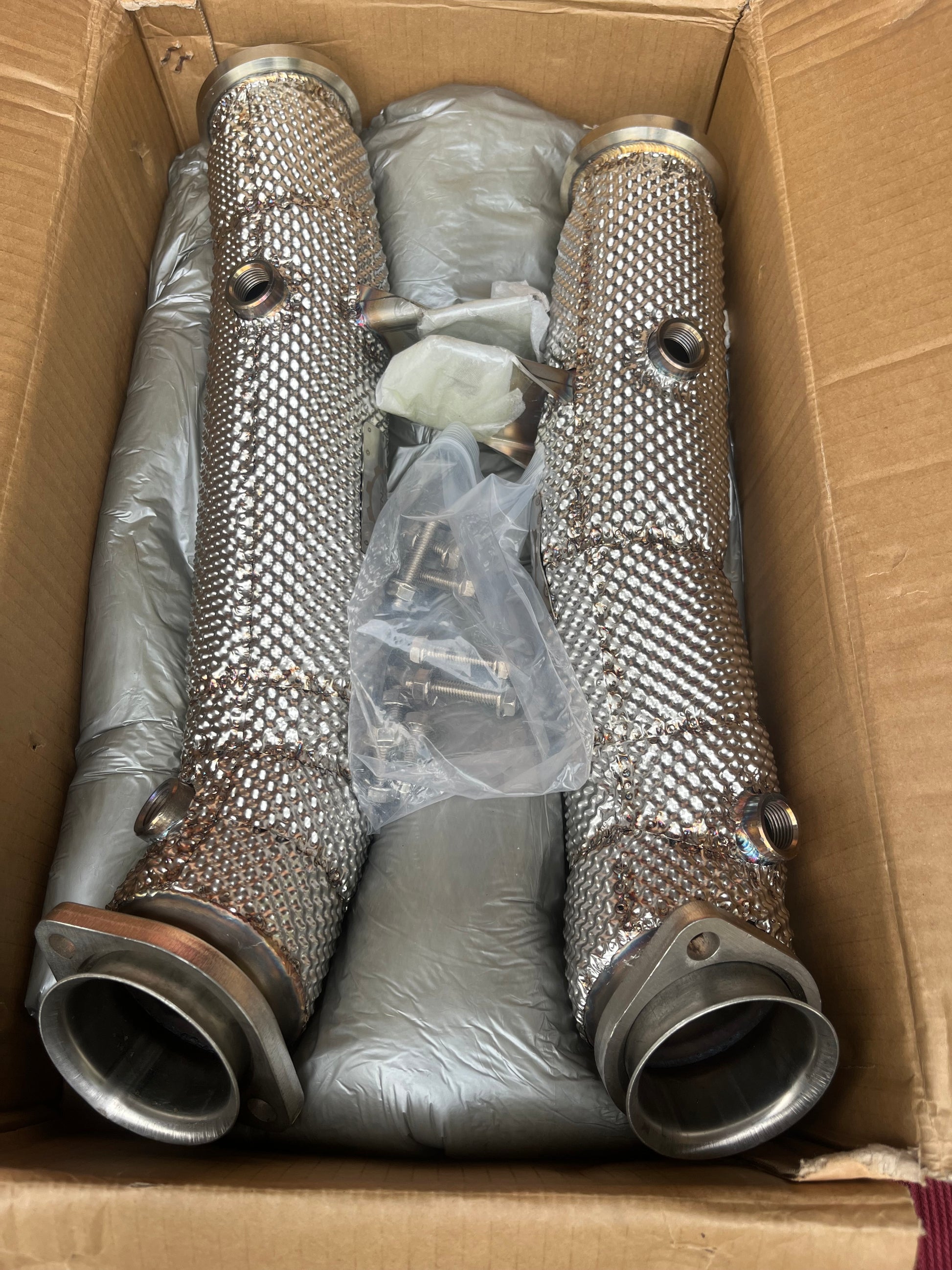 Mercedes M276 catless downpipes – in-box view with packaging and hardware