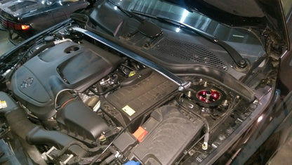 Megan Racing front strut tower bar installed on Mercedes CLA45 AMG engine bay showing chassis reinforcement