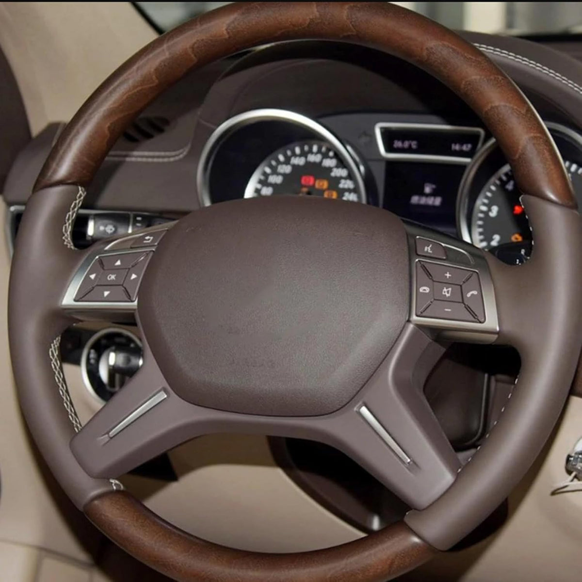 Black button overlays installed on a Mercedes steering wheel in a tan leather interior