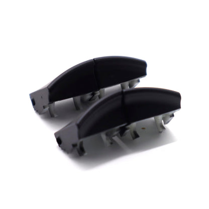 Two black window switch button caps laid out and viewed from the side, showing the curved profile and mounting clips