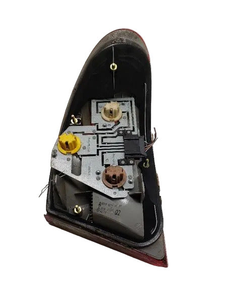 Rear view of genuine used Mercedes W210 driver-side outer tail light 2108203564 showing mounting points and OEM labels