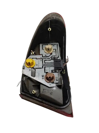 Rear view of genuine used Mercedes W210 driver-side outer tail light 2108203564 showing mounting points and OEM labels
