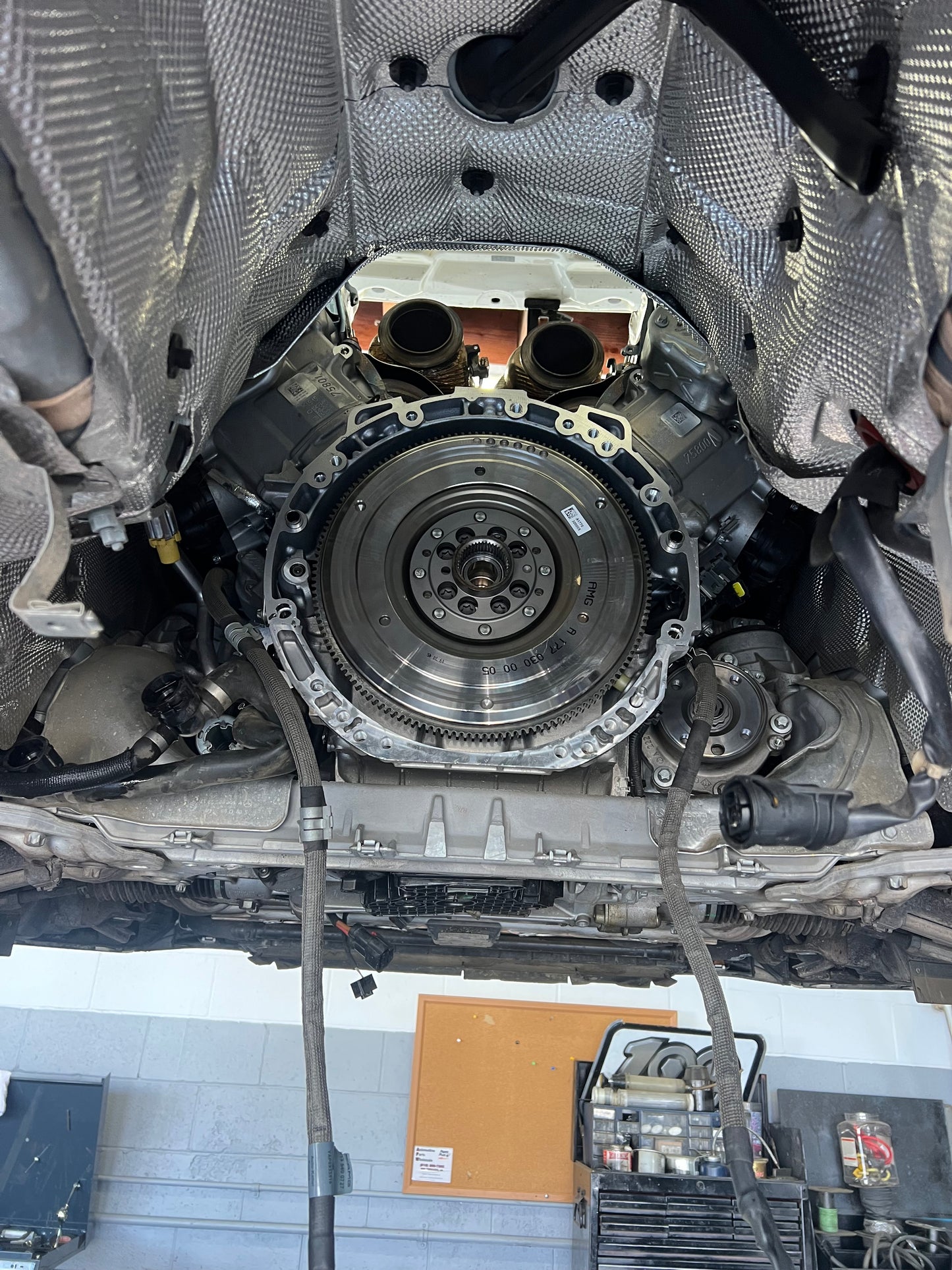W213 E63 AMG bellhousing and flywheel exposed with turbo outlets visible