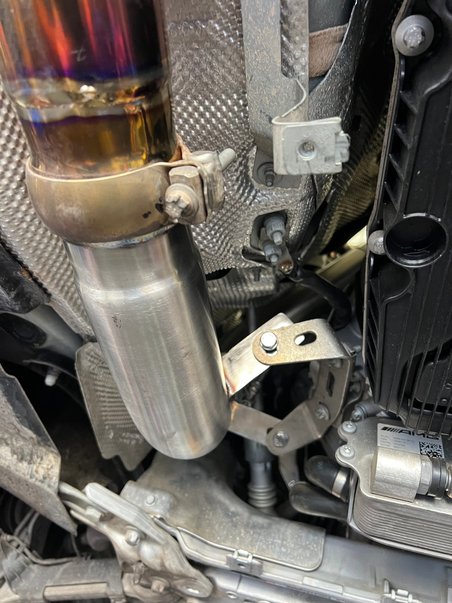 Close-up of V-band clamp securing stainless catless downpipe on W213 E63 AMG