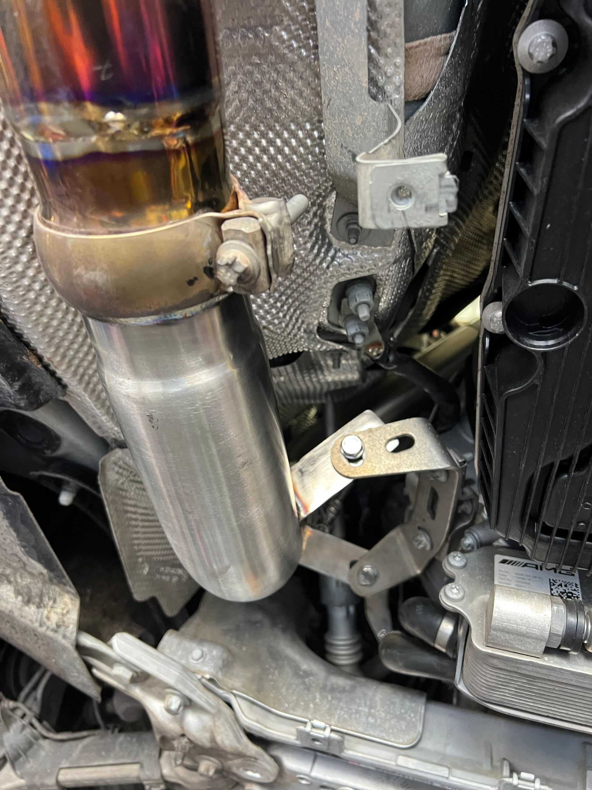 Close-up of V-band clamp securing stainless catless downpipe on W213 E63 AMG
